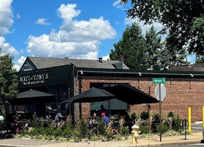 A brick building with a green awning labeled "Matt the Tony's All Day Kitchen Bar".