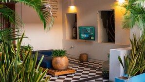A cozy living area with a checkered floor, a blue sofa, and a large woven basket. - La Puerta Azul (Santa Marta)