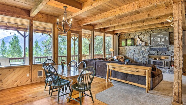 A wooden interior with a dining area, sofa, and fireplace. - Peaceful Cabin w/ Mtn + River Views, Fire Pit (Garden Valley)