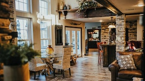 Ein großzügiger Innenraum mit Essbereich, einer Bar und einer Sitzecke mit Ledersofas.