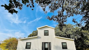 A single-story building with a gabled roof and a small tower-like structure on top. - Muleshoe Room in Red Oak Lodge @ Towering Oaks b&b (Valley View)