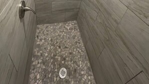 A shower with a tiled floor and a showerhead. - Muleshoe Room in Red Oak Lodge @ Towering Oaks b&b (Valley View)