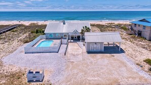 Una propiedad frente al mar con piscina, un patio cubierto y un acceso a la playa.