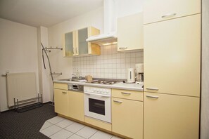 Une cuisine de taille réduite équipée d’une cuisinière, d’un four et d’une machine à café.