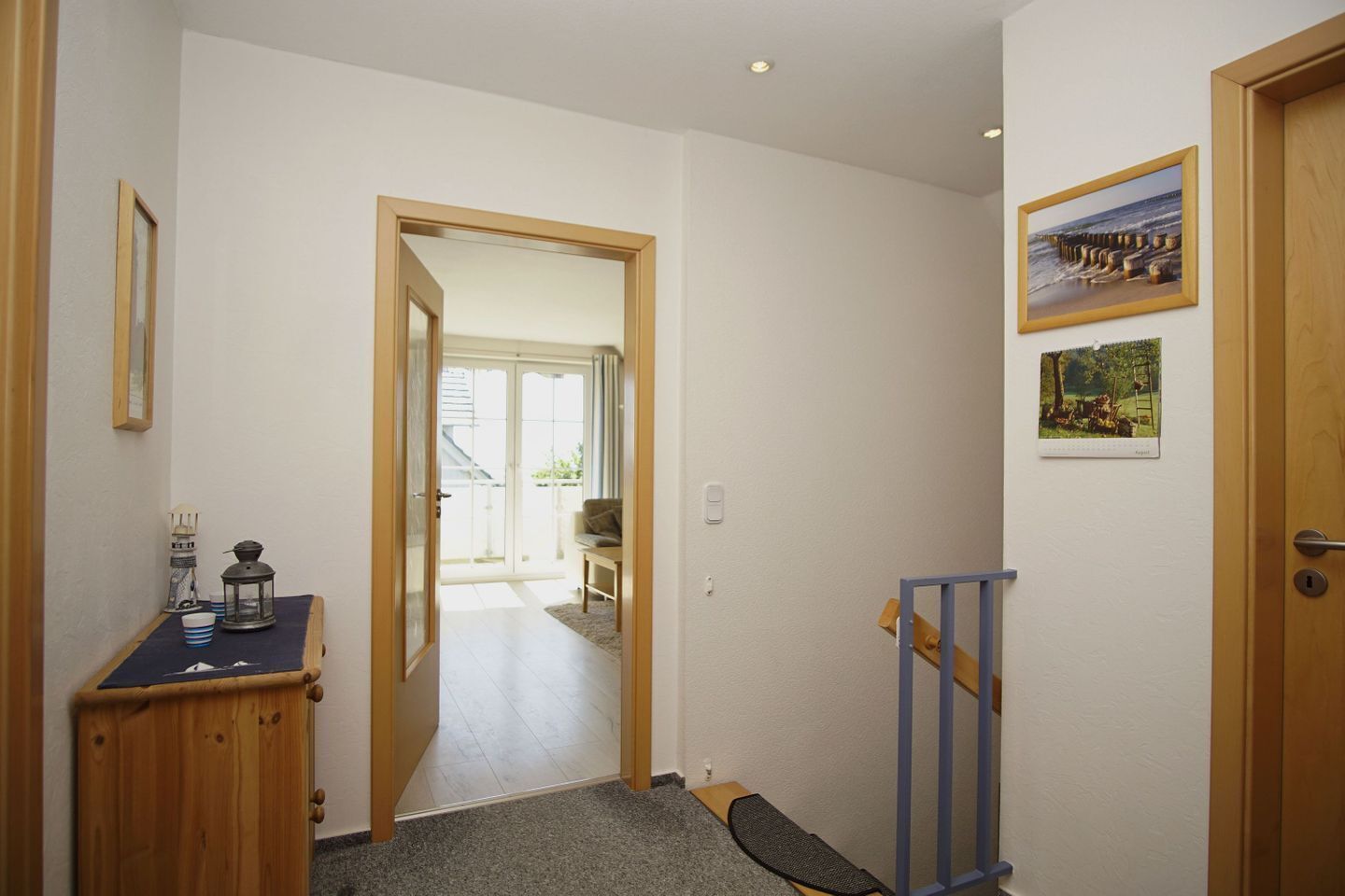 A hallway leading to a balcony with a view of the sea.