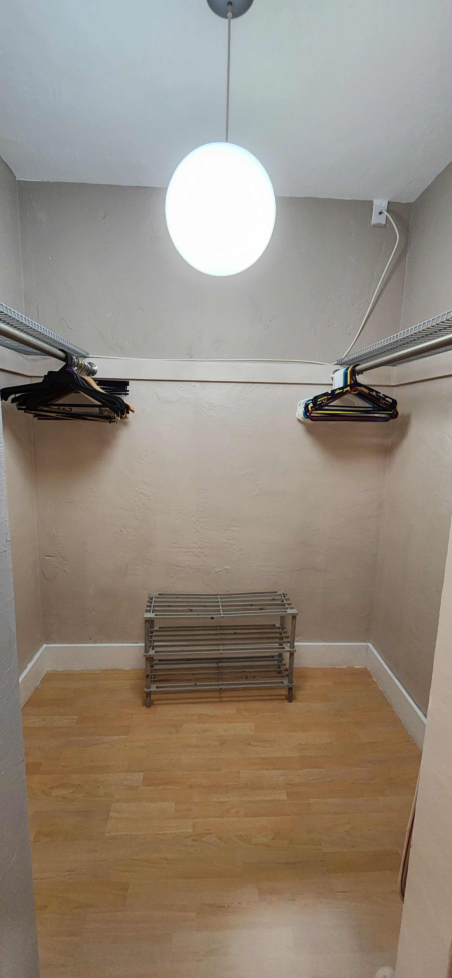 A room with a ceiling light, a radiator, and a clothes drying rack.