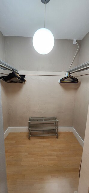 Quarto com luminária no teto, radiador e varal de roupas.