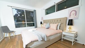 A bedroom with a bed, a chair, a nightstand, and a window. - Family Holiday Entire House 8BRM Vermont (Vermont)