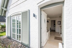 A white building with a stone pathway leading to a door.
