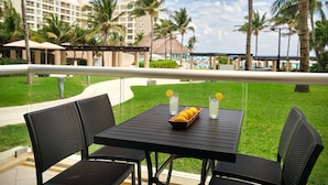 An outdoor dining area with a table and chairs, a tray of lemons, and a glass of water. - 2 Bedroom - Westin Lagunamar Ocean Resort - Full Resort Access (Cancún)