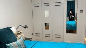 A bedroom with a bed, a wardrobe, and a mirror. - West End 1-Bed Apt, Sleeps 2 with Wi-Fi (London)