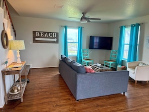 A living room with a sofa, a television, and a sign that reads 'BEACH'.