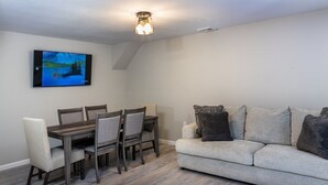 Ein Wohnzimmer mit Essbereich, einer Couch und einem Gemälde an der Wand.