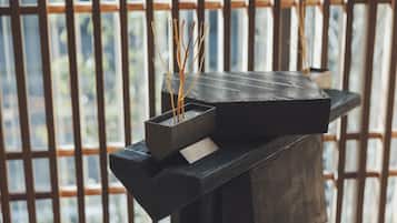 A modern, dark-colored bench with a small, rectangular planter holding dried reeds.