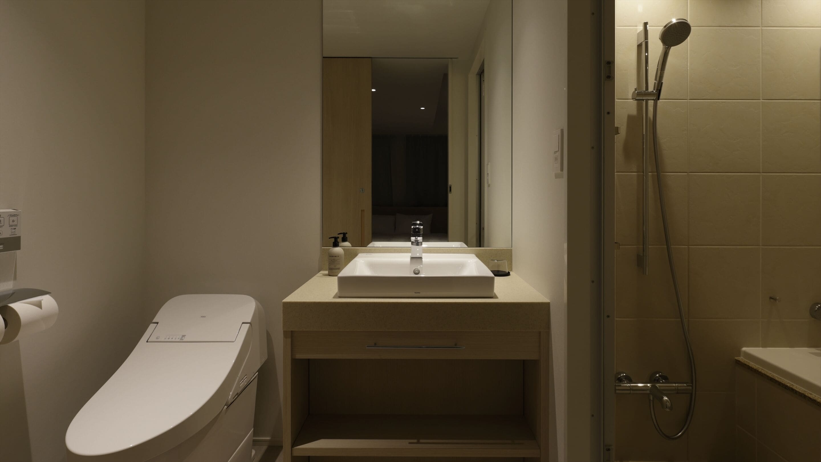 A compact bathroom with a toilet, sink, and shower.