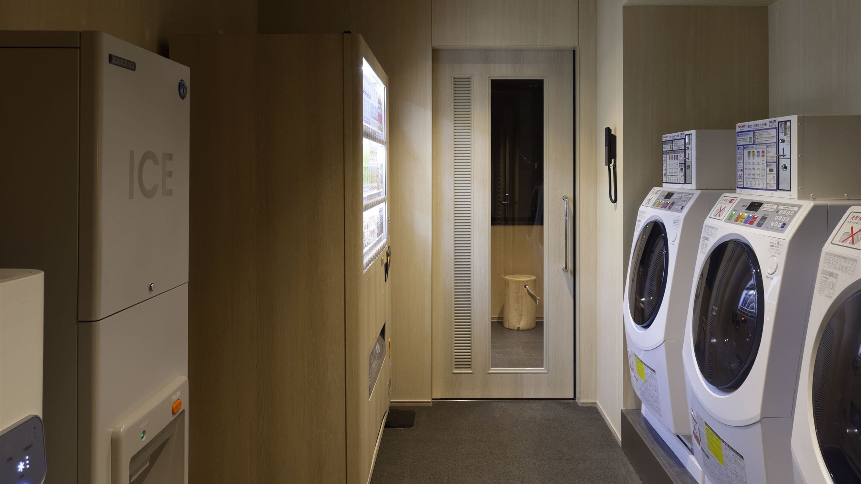A laundry room with a refrigerator, washing machines, and a toilet.