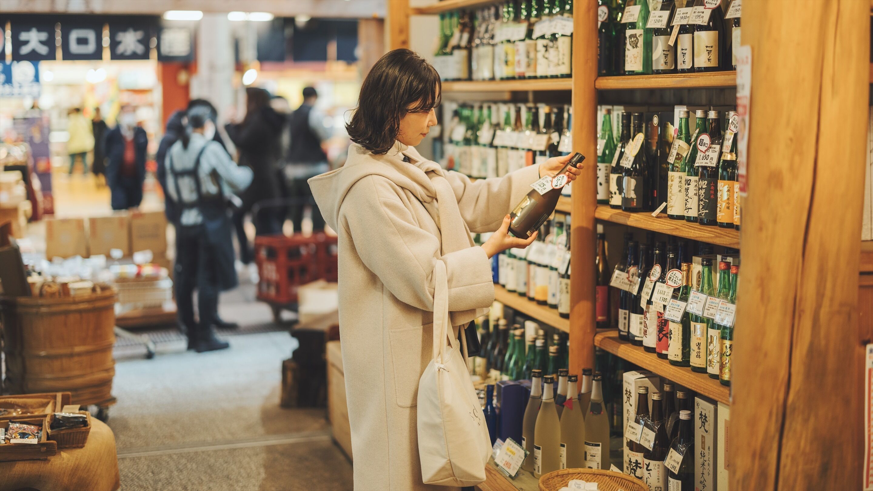 Una persona observa estantes llenos de bebidas embotelladas en una tienda.