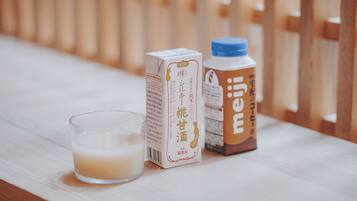 Un verre de lait, un emballage de lait et une bouteille de lait sur une surface en bois.