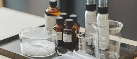 A tray with various essential oil bottles, a glass bowl with salt, and small containers.
