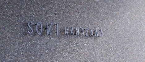 Metal letters spelling "SOIKANZAWA" on a textured surface.