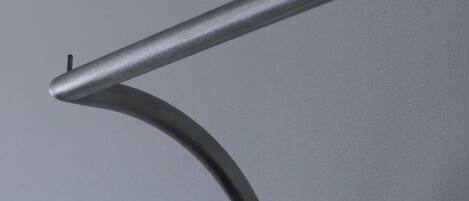 Una estructura metálica curvada con una barra horizontal recta que se extiende desde ella.