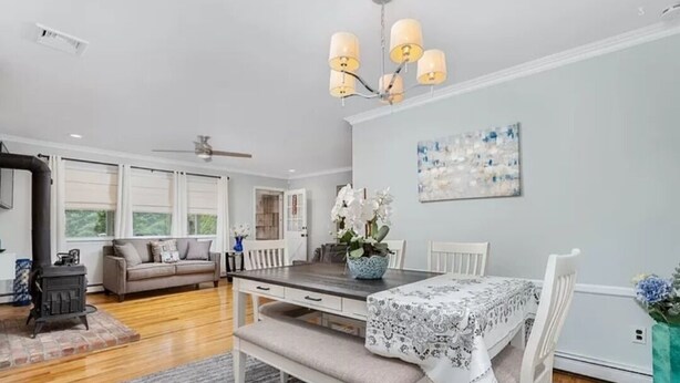 A modern living room with a dining area, a fireplace, and a large window. - Perfect summer getaway in Hampton Bays. Last 2 weeks of Summer, still available! (Hampton Bays)
