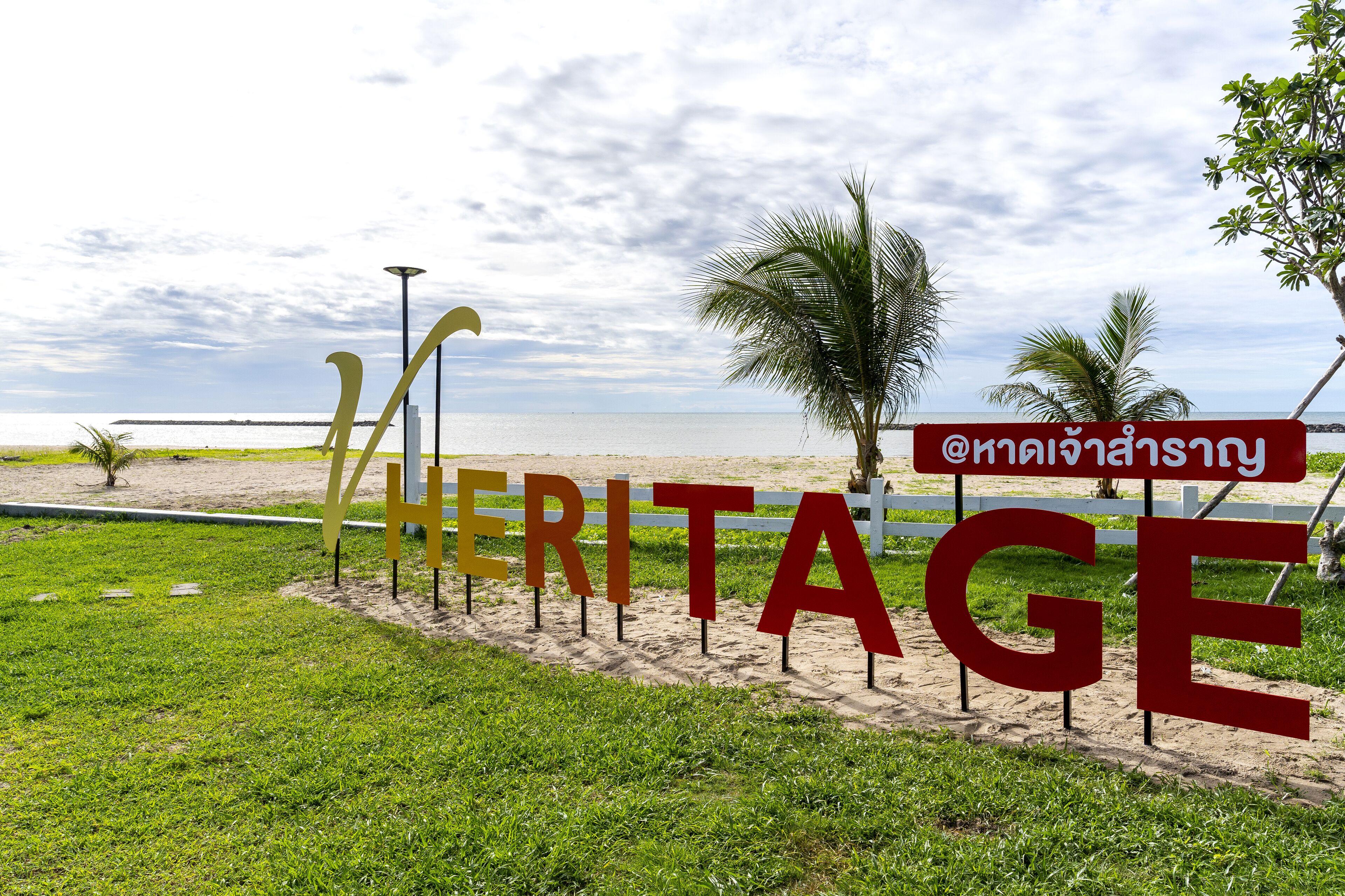 A beach sign with the word "HERITAGE" and a social media handle.