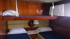 Eine Hütte mit zwei Betten, einem kleinen Tisch und einer Pendelleuchte.