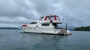 Eine weiße Yacht mit Kabine und rotem Aufbau auf dem Wasser.