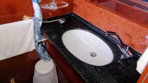 Ein Badezimmer mit einem weißen Waschbecken, einem Handtuchhalter und einem Spiegel.