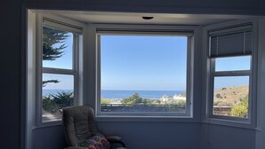 A bedroom with a large bay window overlooking a coastal view. - Stunning ocean views close to beach and SF (Pacifica)