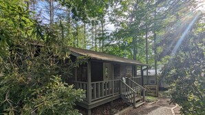 A rustic cabin with a wooden deck and a staircase leading to a porch. - The Linville Community, a restful retreat w/ convenient access to the mountains (Newland)