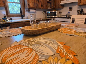 A kitchen with wooden cabinets, a microwave, and a wooden serving tray with glasses. - The Linville Community, a restful retreat watch the changing colors.  (Newland)