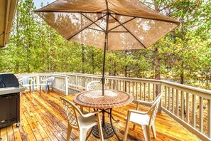 Enjoy al fresco dining on the deck, surrounded by lush trees.