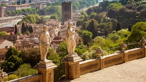 A stone balustrade with statues, a tower, and a cityscape in the background. - Podere Apostoli (Bagno a Ripoli)