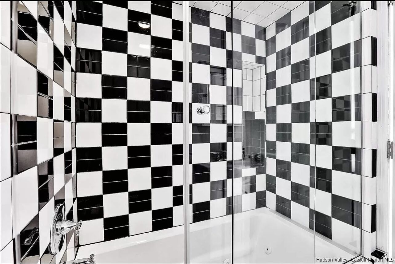 A modern bathroom with a checkered tile pattern on the walls and floor.