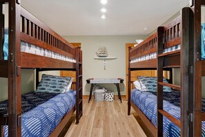 A room with two bunk beds, a small table, and a shelf with decorative items. - Hilltop Hideaway at Center Hill Lake(Trailer Parking) (Lancaster)