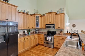 A kitchen with wooden cabinets, stainless steel appliances, and a granite countertop. - Hilltop Hideaway at Center Hill Lake(Trailer Parking) (Lancaster)