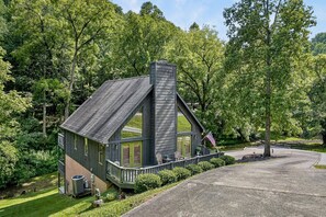 A cabin with a steep roof, a chimney, and a porch with outdoor seating. - Hilltop Hideaway at Center Hill Lake(Trailer Parking) (Lancaster)