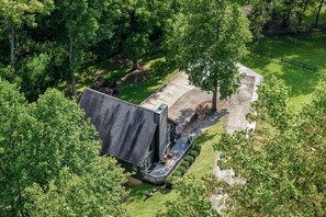 Une maison de plain-pied, dotée d’un toit en pente et entourée d’une végétation luxuriante.