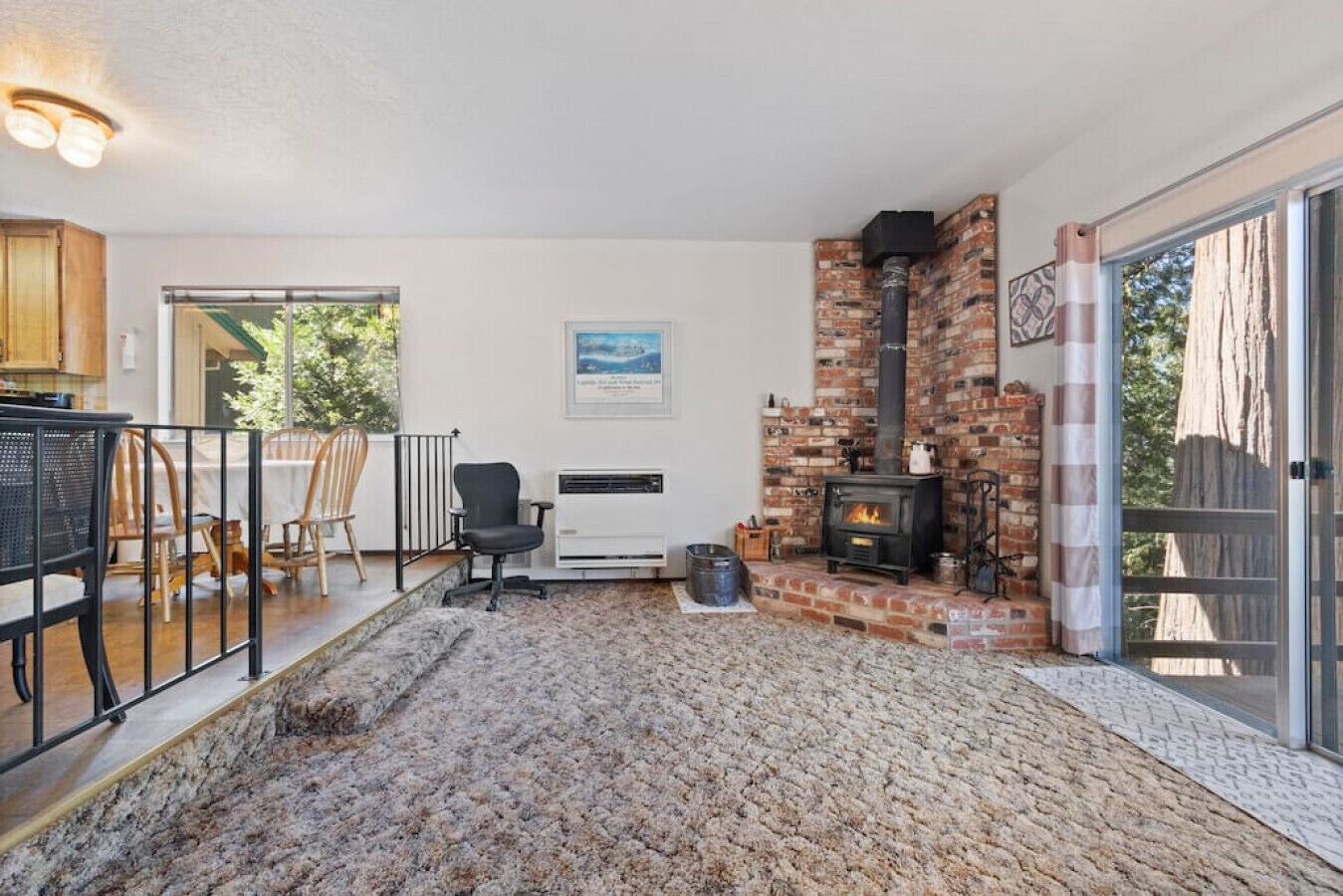 Una habitación acogedora con chimenea, un comedor con sillas y vistas al exterior.