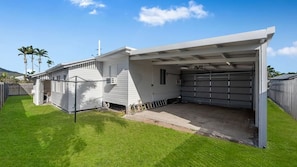 A residential property with a garage, a covered patio, and a well-maintained lawn.