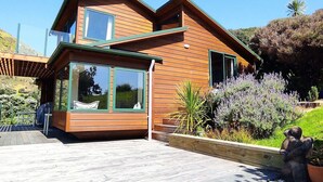 A modern house with a wooden exterior, large windows, and a deck.