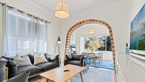 Un salon moderne comprenant un ensemble de canapés, une table basse et un coin repas avec des chaises.