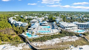 An aerial view of a resort with multiple buildings, a large central pool, and a beach area. - Short Walk to Beach Club, Close to Seaside | 3BR Home + Carriage House (Santa Rosa Beach)