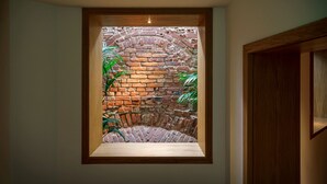 A framed view of a brick archway with plants, a wooden bench, and a door frame. - La Boheme (Bucharest)