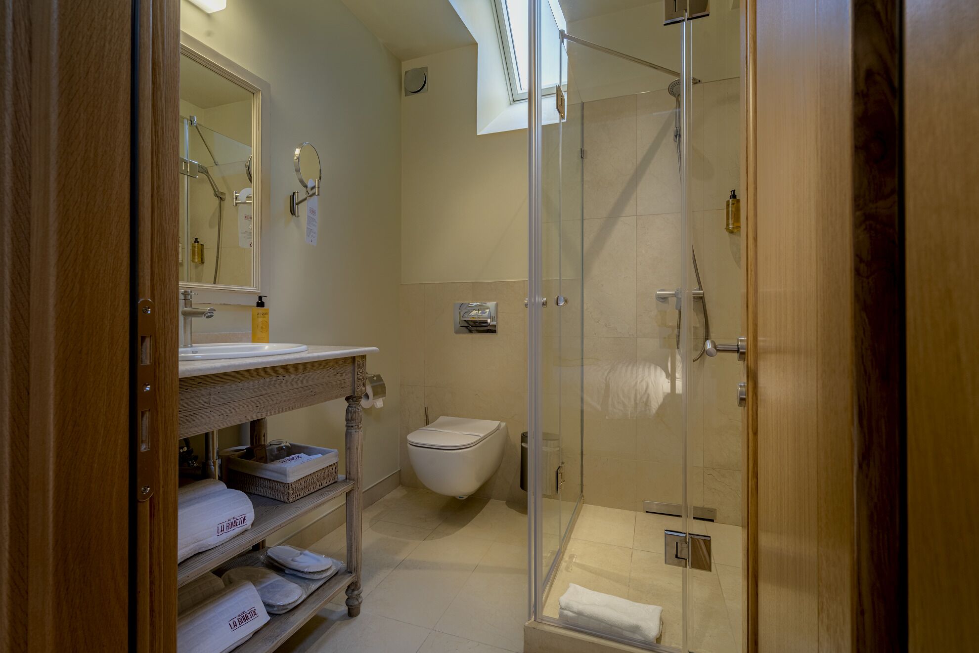 A bathroom with a glass-enclosed shower, a toilet, and a vanity with a mirror and sink.