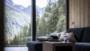 A modern living room with a large window overlooking a mountainous landscape.
