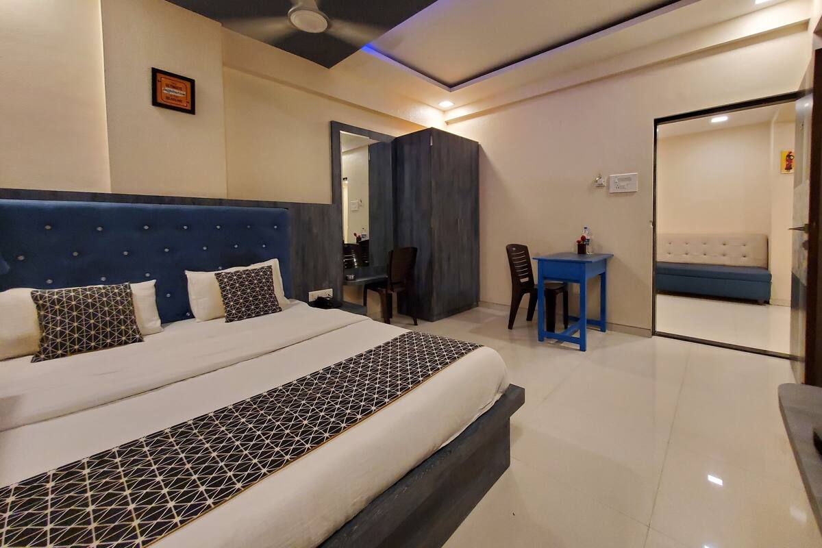 Een hotelkamer met een bed, bureau, stoel en bank.