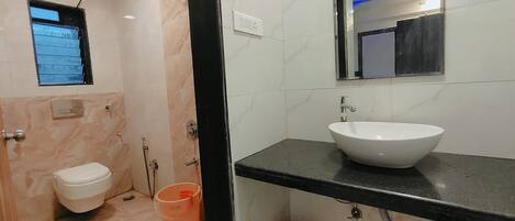 A bathroom with a toilet, sink, and shower.